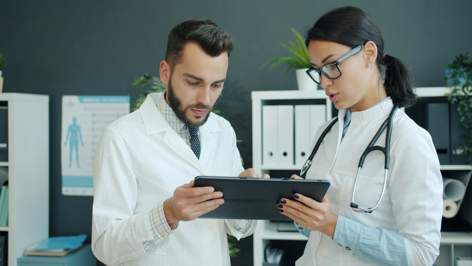 Due professionisti sanitari discutono una demo di gestionale su tablet in poliambulatorio